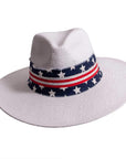 A front view of Knox white straw sun hat with US flag designed hat band