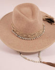 A top view of a cream cowboy hat with a beaded hat band