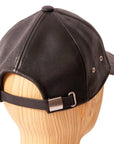 A back view of Sidecar Black Leather Cap for Men placed on a wooden stand